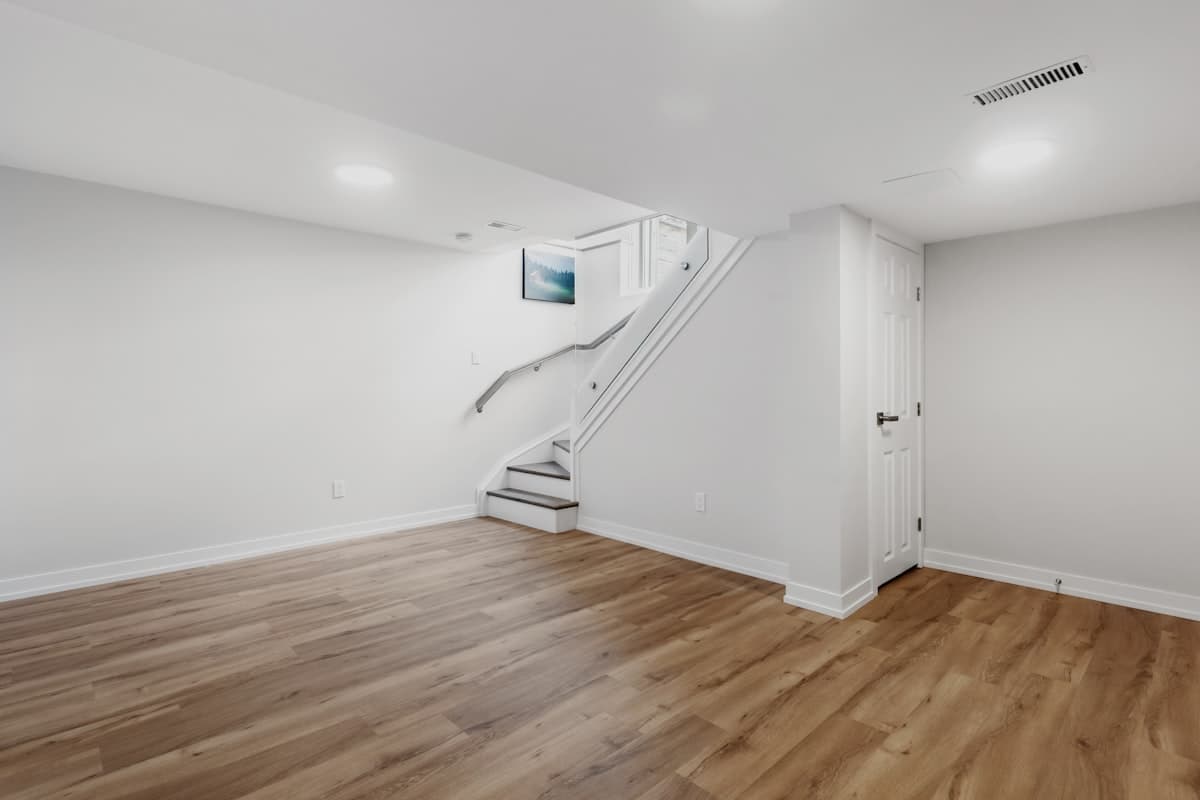 Finished basement recreation room with recessed lighting and plank flooring